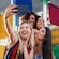 4 girls take a selfie in front of a structure of glass panels